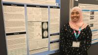 Photo of an MS student presenting her poster at a conference.